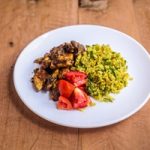 A bowl of chicken curry served with cauliflower rice